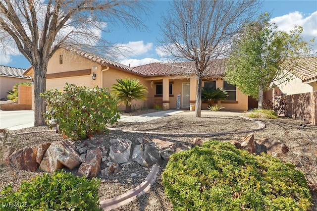 view of front of property with a garage, driveway, a tiled roof, and stucco siding