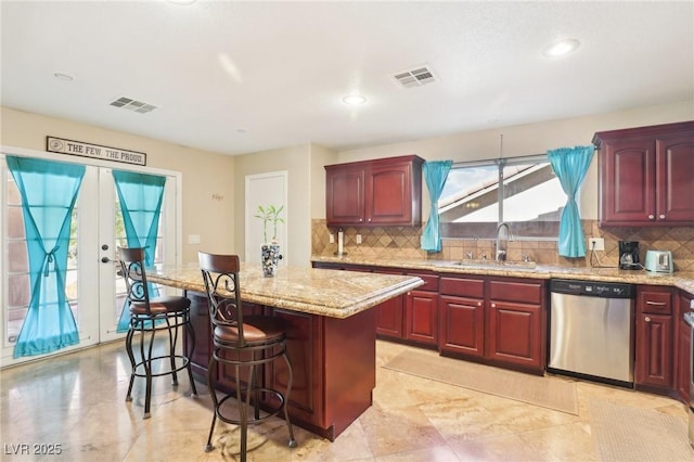 kitchen with a sink, visible vents, stainless steel dishwasher, and a center island