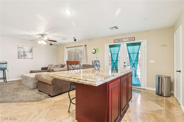 kitchen with plenty of natural light, visible vents, a breakfast bar, and a center island