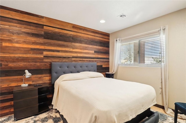 bedroom with recessed lighting and wooden walls