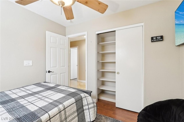 bedroom featuring ceiling fan, a closet, and wood finished floors