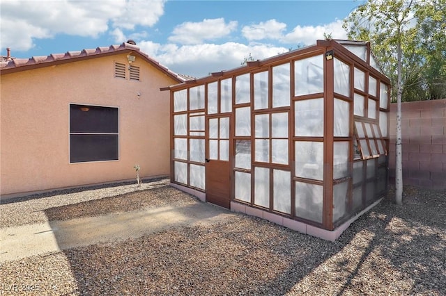 view of outdoor structure featuring fence and an outdoor structure