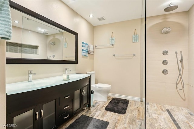 bathroom with walk in shower, a sink, visible vents, and wood finished floors