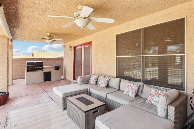 view of patio / terrace featuring a grill, ceiling fan, fence, exterior kitchen, and an outdoor living space