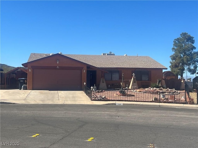 single story home with driveway, fence, an attached garage, and stucco siding