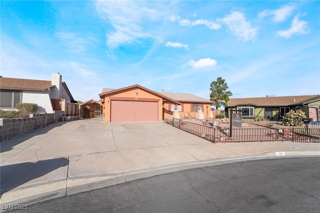 ranch-style home featuring a garage, concrete driveway, a fenced front yard, and a residential view