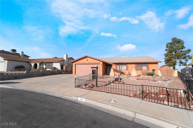 ranch-style house with driveway, a fenced front yard, a garage, and stucco siding