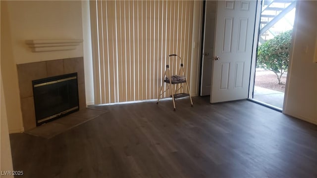 unfurnished living room with dark wood-style flooring and a fireplace