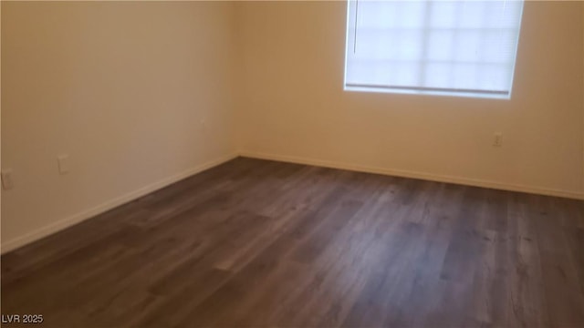 empty room with dark wood-style flooring and baseboards