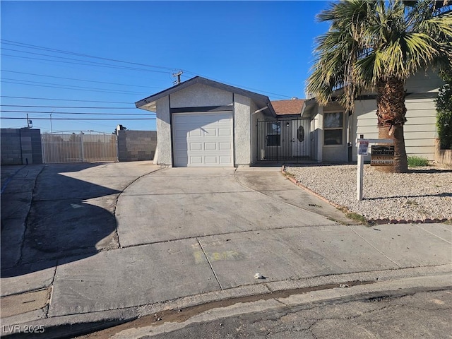 view of front of property featuring a garage, fence, concrete driveway, and stucco siding