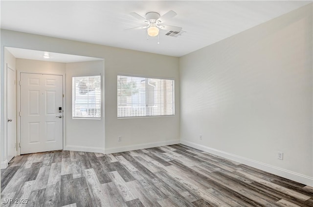 foyer with baseboards, visible vents, ceiling fan, and wood finished floors