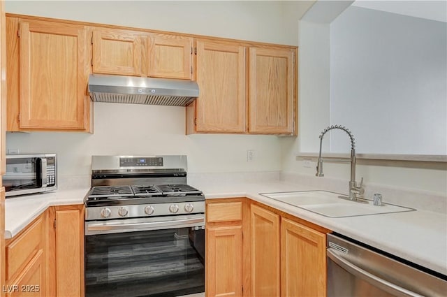 kitchen featuring under cabinet range hood, light brown cabinets, stainless steel appliances, and a sink