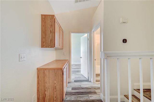 corridor featuring light wood-style floors and visible vents