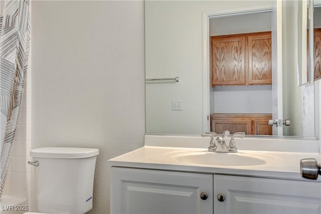 bathroom featuring a shower with shower curtain, vanity, and toilet