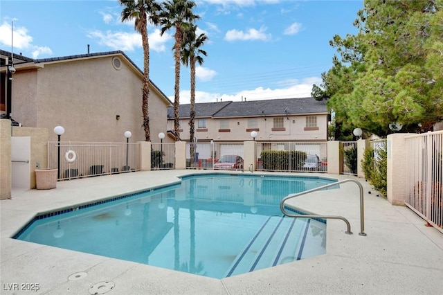 community pool featuring fence and a patio