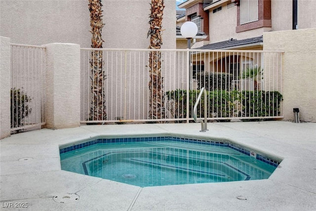 view of pool featuring an in ground hot tub and fence