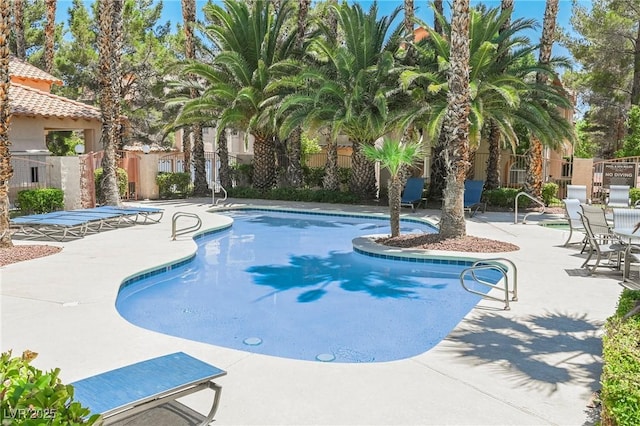 community pool featuring a patio area and fence