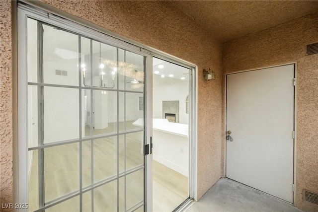 entrance to property featuring visible vents and stucco siding