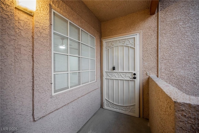 doorway to property featuring a balcony and stucco siding