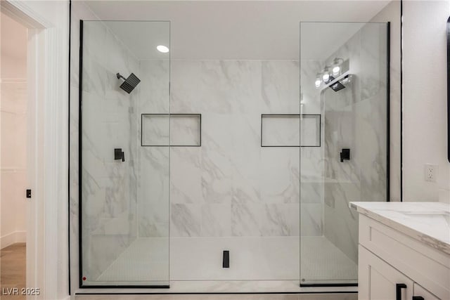 bathroom featuring a shower stall and vanity