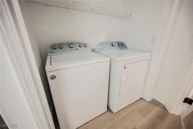 laundry room featuring laundry area, light wood finished floors, and washing machine and clothes dryer