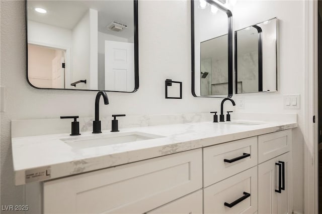 full bath featuring visible vents, a sink, and double vanity