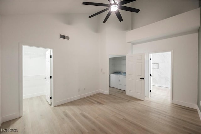 unfurnished living room with light wood-style floors, visible vents, washer and clothes dryer, and baseboards