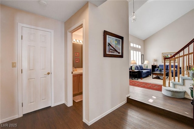 interior space with dark wood-type flooring, stairway, and baseboards