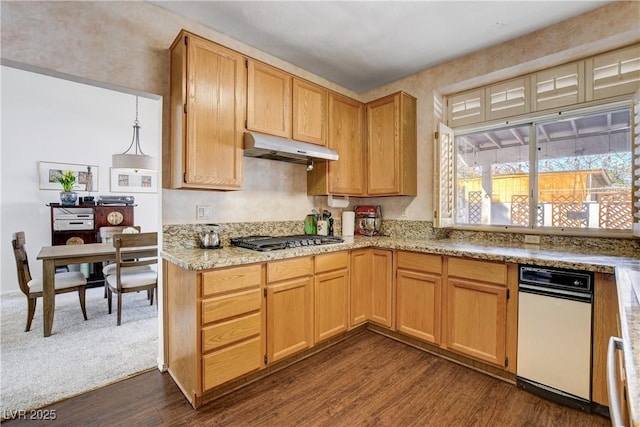 kitchen with light stone counters, under cabinet range hood, stainless steel gas cooktop, dark wood-style flooring, and pendant lighting