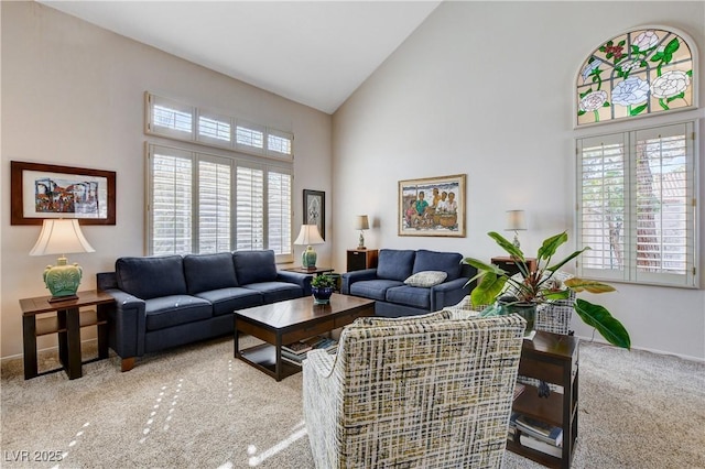 living area with carpet floors and high vaulted ceiling