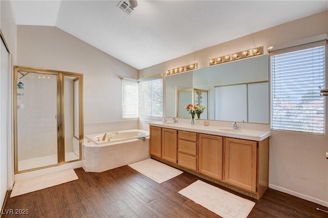 full bath featuring a stall shower, visible vents, wood finished floors, vaulted ceiling, and a bath