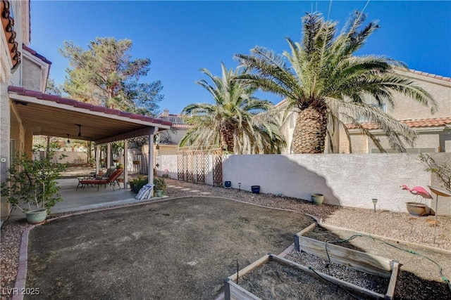 view of yard with a fenced backyard, ceiling fan, and a patio