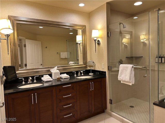 bathroom featuring a stall shower, a sink, and tile patterned floors