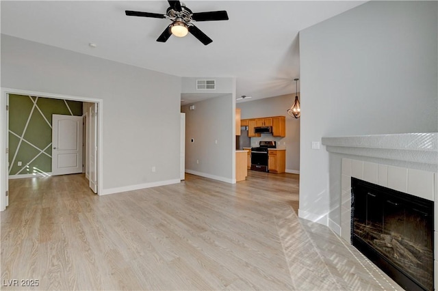 unfurnished living room with a fireplace, light wood finished floors, visible vents, a ceiling fan, and baseboards