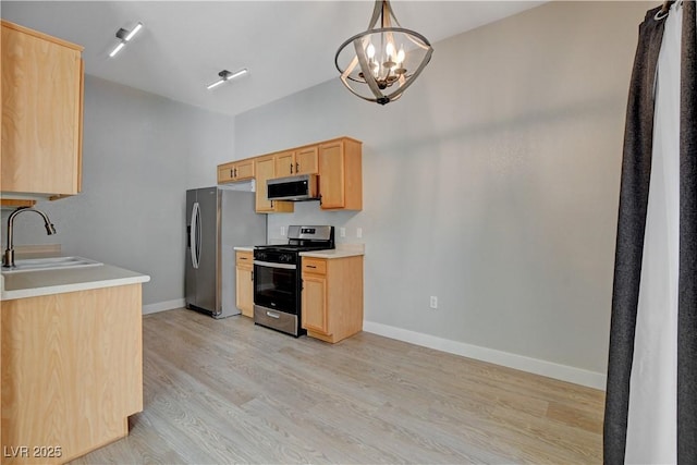 kitchen featuring decorative light fixtures, an inviting chandelier, stainless steel appliances, light countertops, and a sink