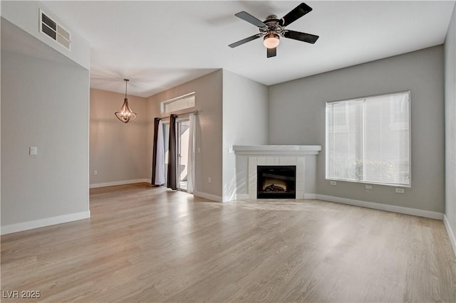 unfurnished living room featuring ceiling fan, light wood-type flooring, visible vents, and baseboards