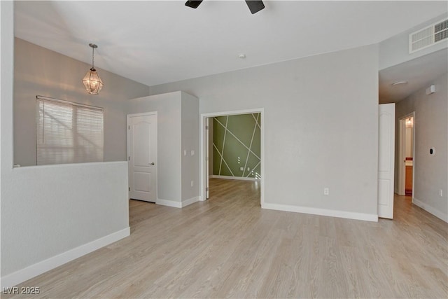 spare room with baseboards, visible vents, and light wood-style floors