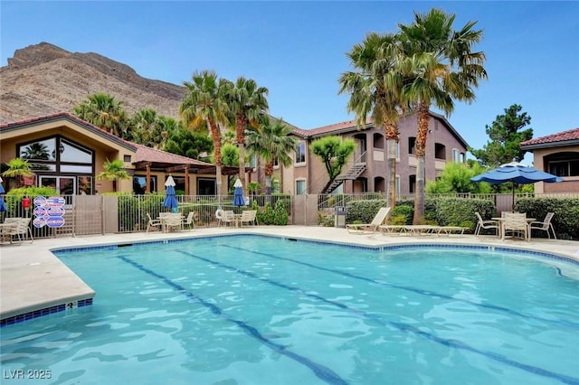 community pool featuring fence and a mountain view