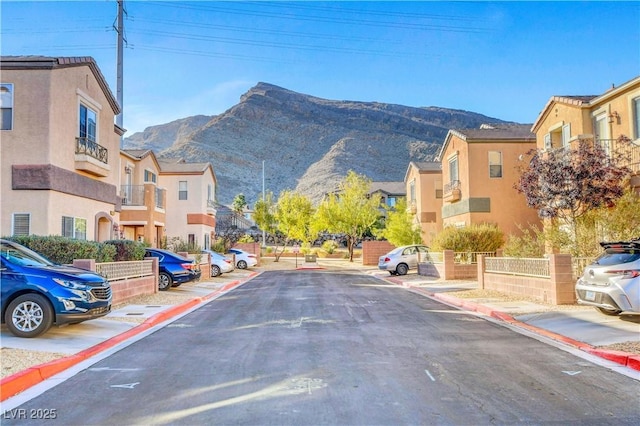 view of street with a residential view, sidewalks, a mountain view, and curbs