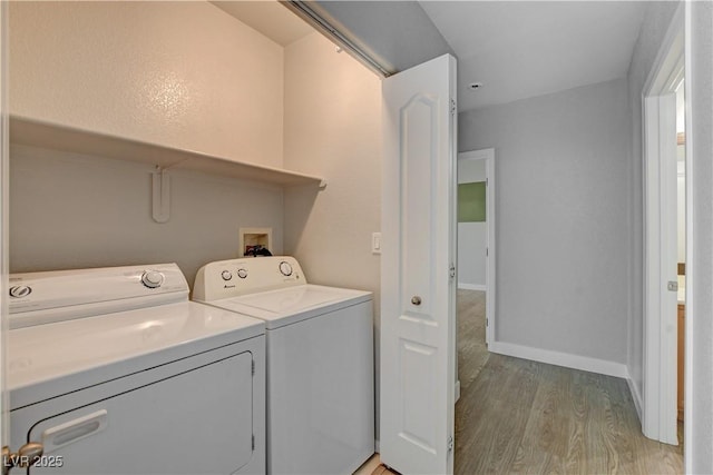 laundry room with light wood finished floors, laundry area, separate washer and dryer, and baseboards