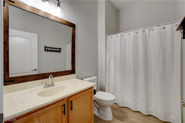 full bathroom with curtained shower, vanity, toilet, and wood finished floors