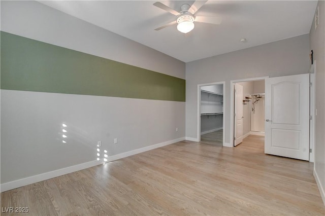 interior space with baseboards, ceiling fan, and light wood finished floors