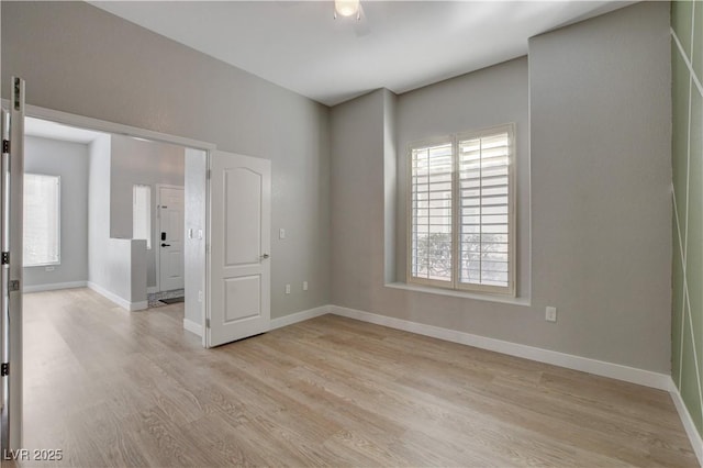 unfurnished room featuring light wood-style flooring and baseboards