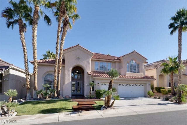 mediterranean / spanish home featuring driveway, a tiled roof, an attached garage, and stucco siding