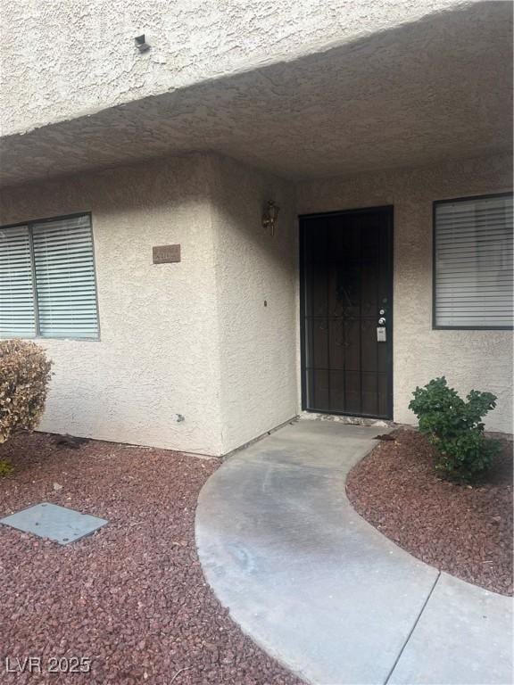 entrance to property with stucco siding