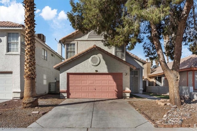 view of front of property with an attached garage, central AC, a tile roof, concrete driveway, and stucco siding