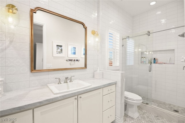 full bath with tile patterned floors, toilet, tile walls, a shower stall, and vanity