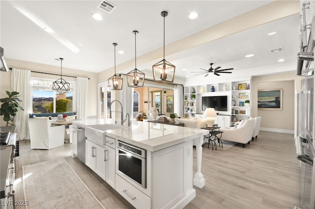 kitchen with light wood-style floors, visible vents, appliances with stainless steel finishes, and a sink