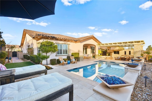 rear view of house with a patio area, an outdoor kitchen, a tiled roof, and fence