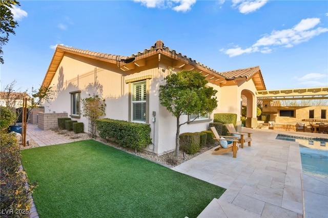 back of house with a pergola, stucco siding, outdoor lounge area, a tile roof, and a patio area